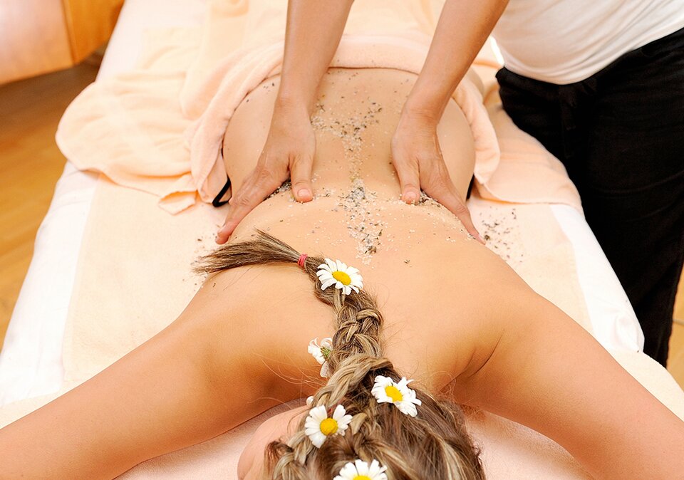 Dame wird mit Gartnerkofel Peeling bei einer Massage behandelt