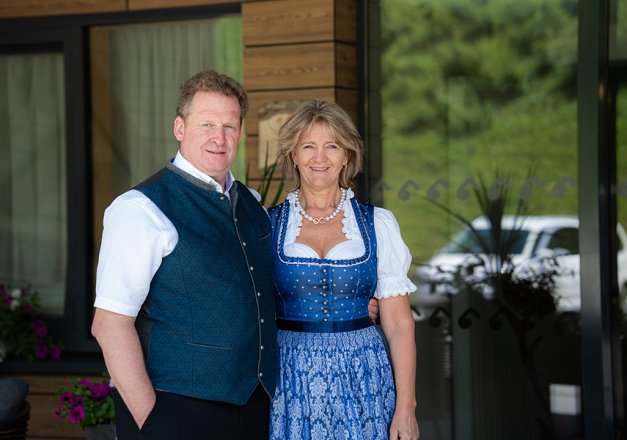 Gastgeber in Tracht vor dem Hoteleingang