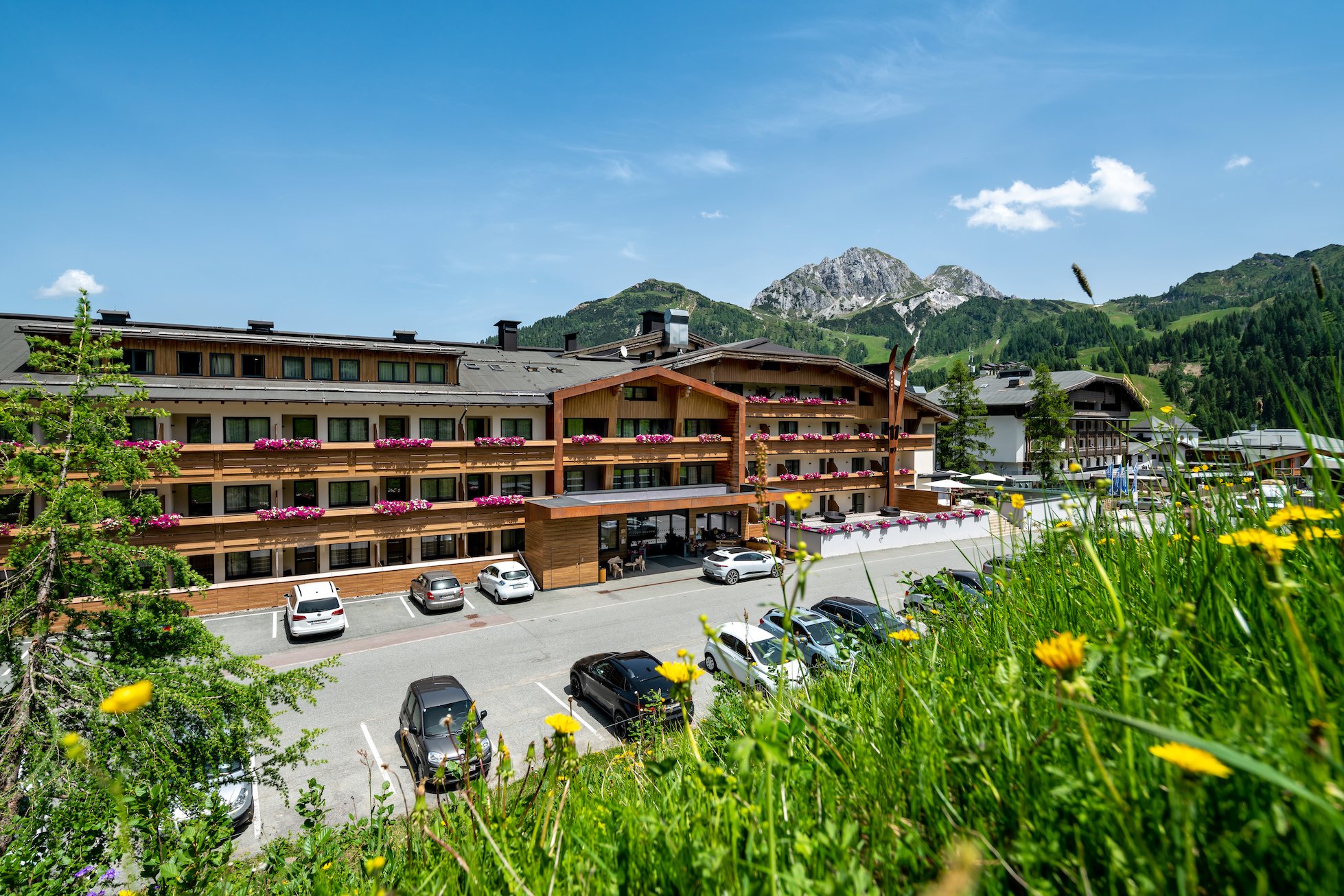 Hotel mit Bergkulisse und Blumenwiese