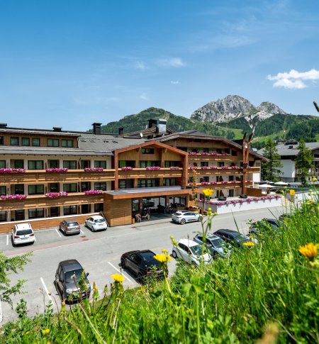 Hotel mit Bergkulisse und Blumenwiese