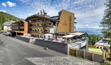 Hotel with panoramic terrace and flower balconies by the forest edge        Ask ChatGPT