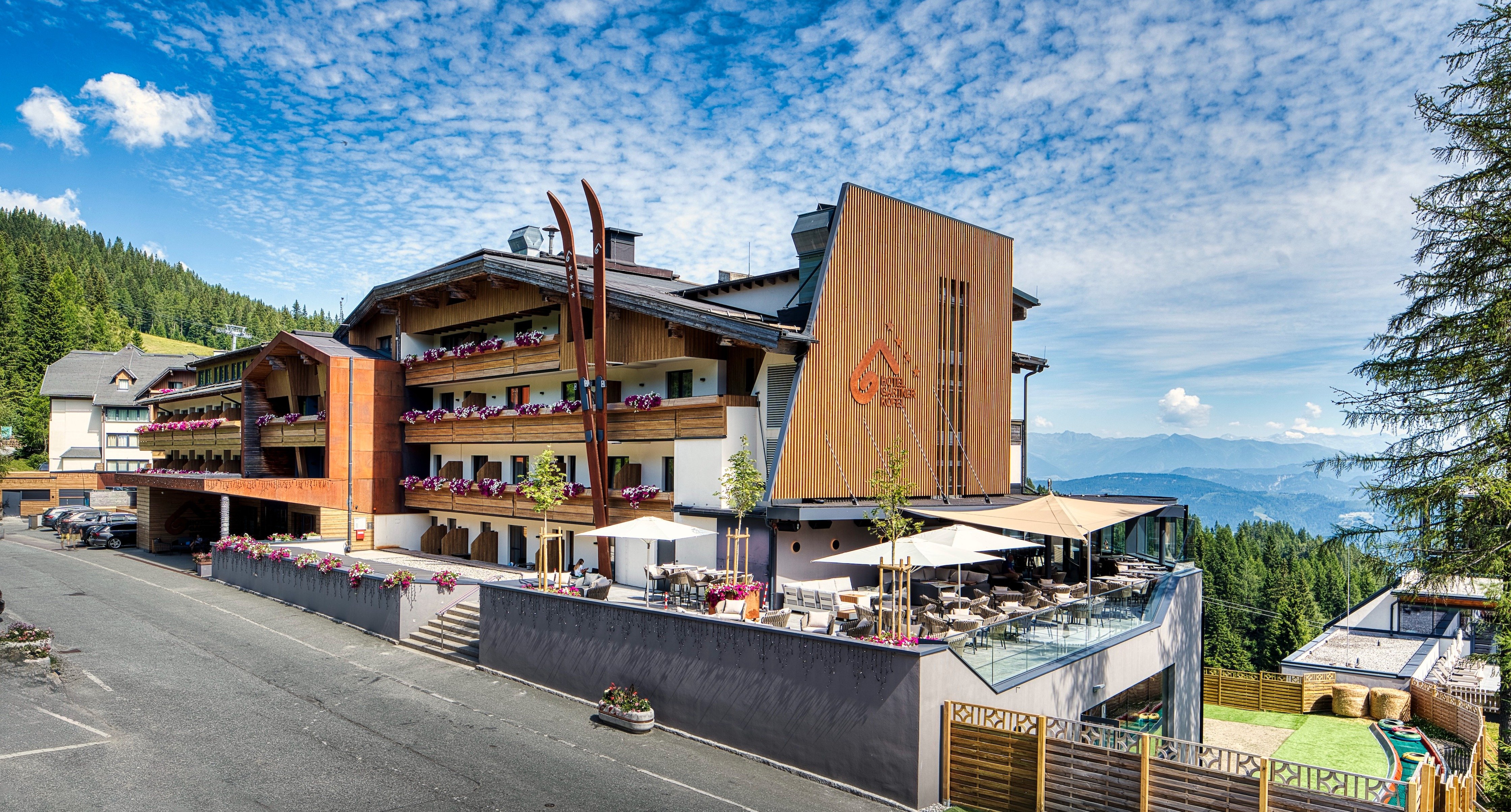 Hotel mit Panoramaterrasse und Blumenbalkonen am Waldrand