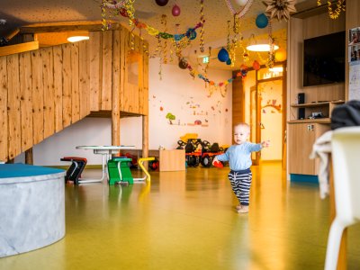 Spielzimmer mit bunten Dekorationen und einem Kleinkind