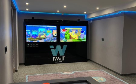 Indoor room with air hockey table in front and two gaming screens on the wall