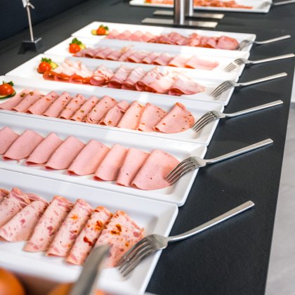 Variety of cold cuts on trays at the breakfast buffet