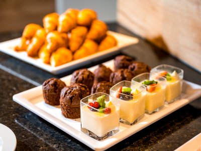 Frisches Frühstücksbuffet mit Croissants, Muffins und Dessert im Glas