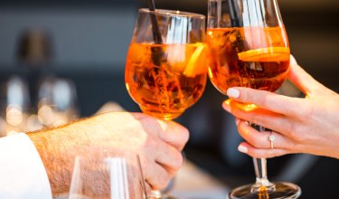 Two Aperol glasses making a toast