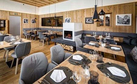 Cozy restaurant with fireplace, wooden walls and elegantly set tables