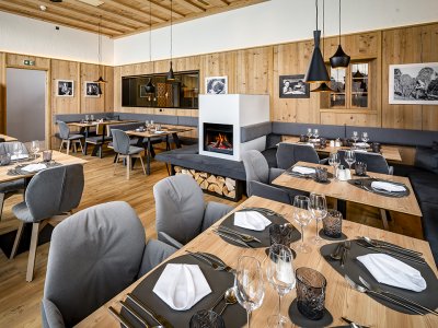 Cozy restaurant with fireplace, wooden walls and elegantly set tables