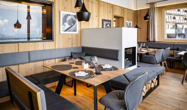Stylishly set table in cozy restaurant with fireplace and wood decor        Ask ChatGPT