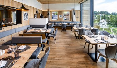 Bright restaurant area with large windows and nature view