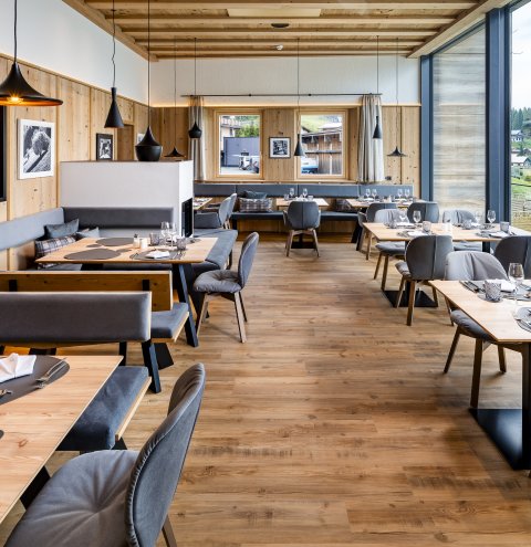 Heller Restaurantbereich mit großen Fenstern und Blick auf die Natur