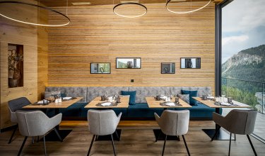 Restaurant with mountain view, wooden wall and elegant booth seating with bench        Ask ChatGPT