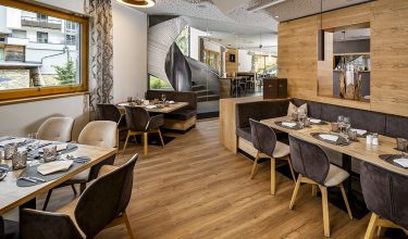 Modern restaurant with cozy booths and view of spiral staircase