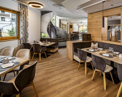 Modernes Restaurant mit gemütlichen Sitzecken und Blick auf Wendeltreppe