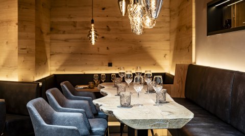 Stylish table with natural wood top, leather chairs and designer lighting        Ask ChatGPT