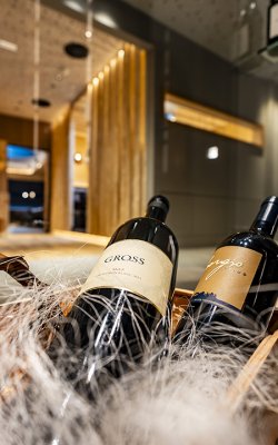 Two wine bottles decoratively placed in a basket in front of modern interior        Ask ChatGPT