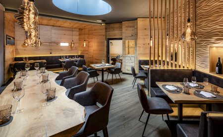 Exklusive Weinstube mit Naturholztisch, Designleuchten und Ledersitzen