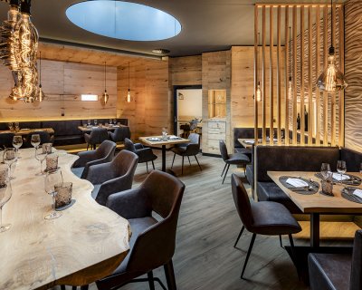 Exklusive Weinstube mit Naturholztisch, Designleuchten und Ledersitzen