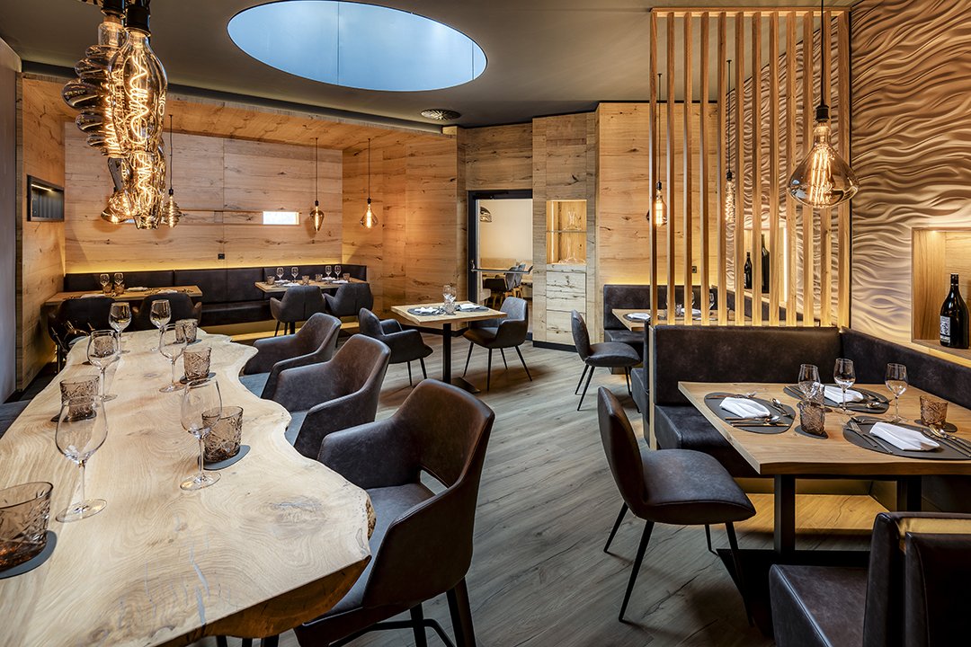 Exclusive wine lounge with natural wood table, designer lights and leather seating