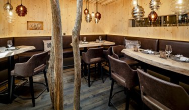 Cozy parlour with natural wood tables and padded bench seating