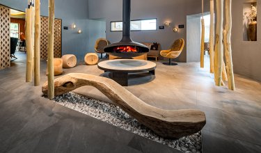 Modernes Loungezimmer mit Hängesesseln und offenem Kamin