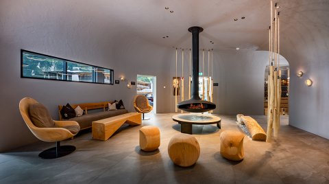 Design-Lounge mit zentralem Kamin und Holzsitzmöbeln
