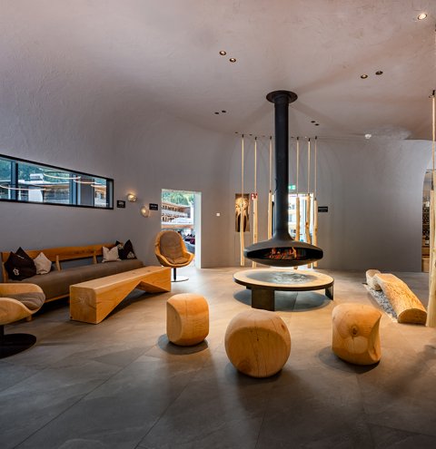 Design lounge with central fireplace and wooden seating