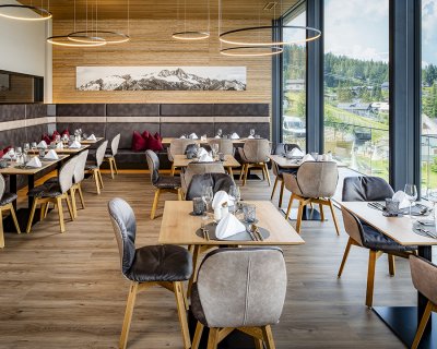 Modernes Restaurant mit Panoramafenstern und elegant gedeckten Tischen