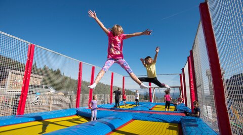 Kinder springen am 4-Feld-Riesentrampolin