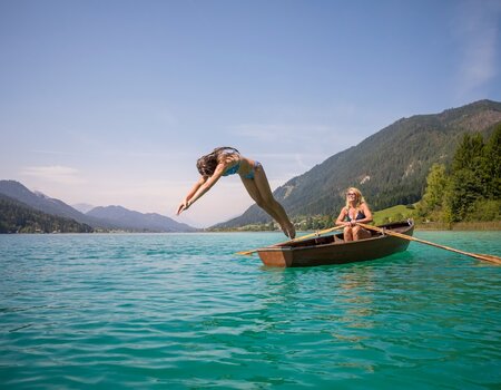 Mädchen springt vom Ruderboot ins Wasser