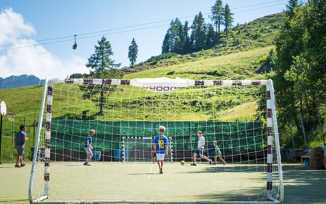 Mehrere Jungs spielen Fussball mit Blick auf die Berge