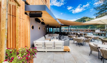 Blumenreiche Terrasse mit bequemen Sesseln im Freien