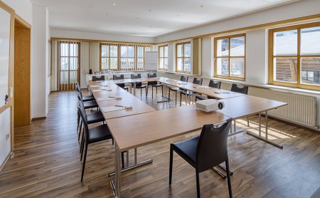 Bright seminar room with wooden floor, projector and flipchart