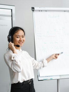 Frau hält eine Präsentation mit Headset und Whiteboard