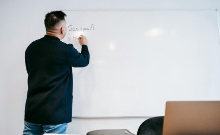 Mann schreibt mit Marker auf Whiteboard