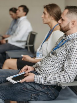 Zuhörer in einem Seminarraum mit Namensschildern
