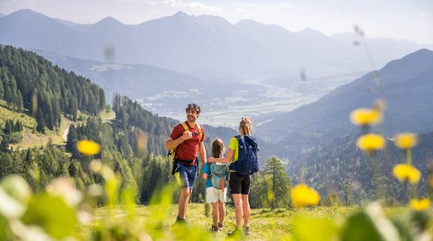 Familie bei einer Wanderung auf einem Bergpfad mit Aussicht