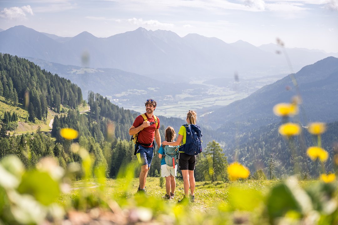 Familie bei einer Wanderung auf einem Bergpfad mit Aussicht