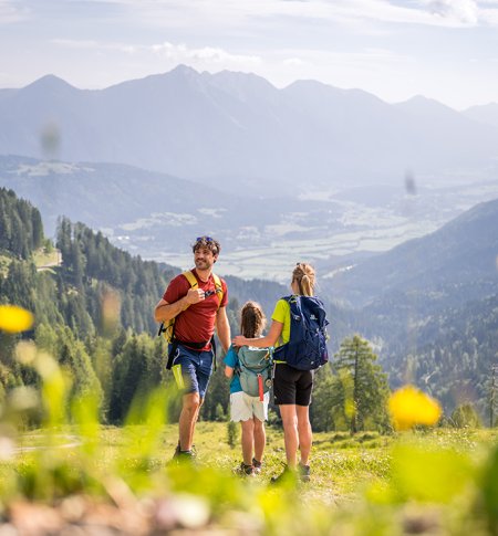Familie bei einer Wanderung auf einem Bergpfad mit Aussicht