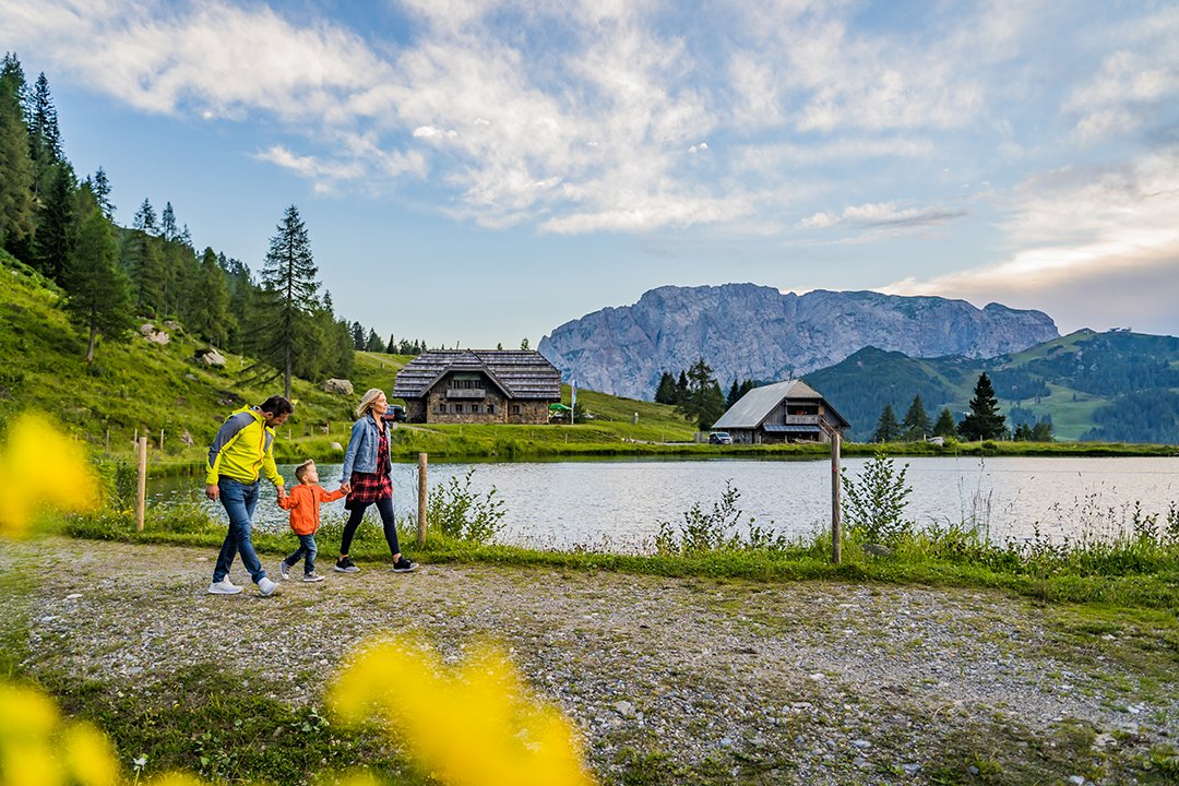 Familie bei einem Spaziergang am See mit Bergpanorama