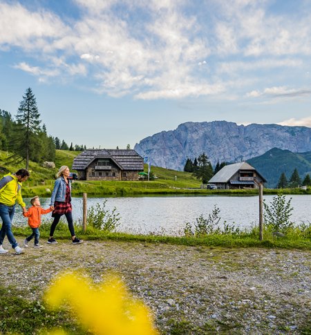 Familie bei einem Spaziergang am See mit Bergpanorama