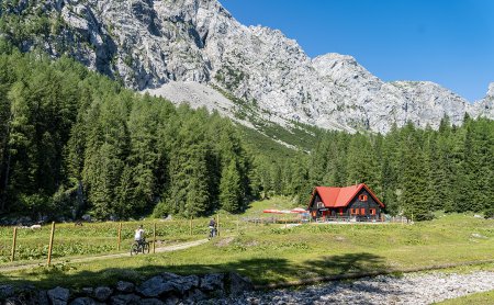 Two cyclists on trail to hut in the mountains