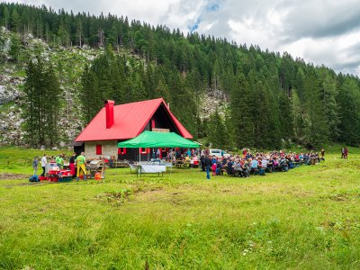 Menschen genießen ein Fest im Freien vor einer Berghütte
