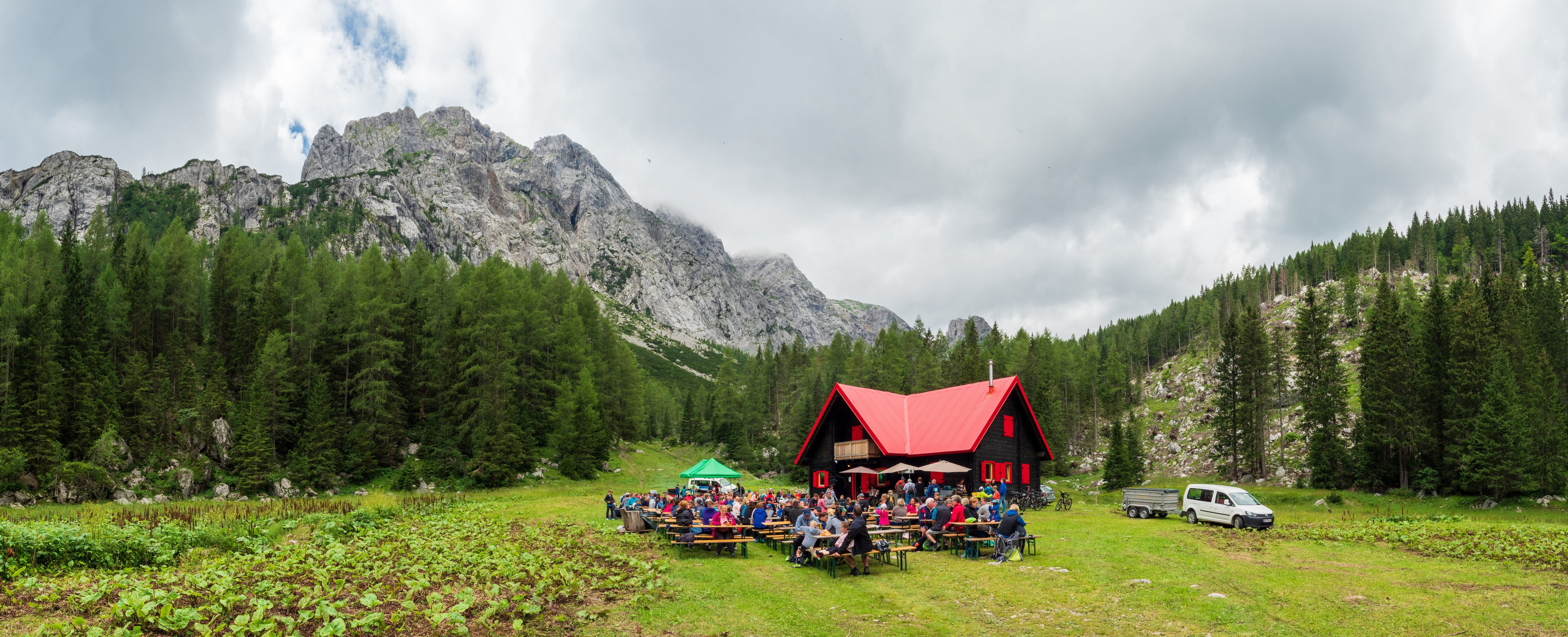 Panoramic view of a celebration in front of a mountain hut