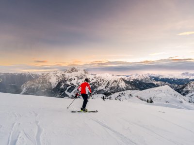 Frau beim Sonnenaufgang am Berg beim Skifahren