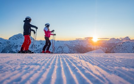 Skiers enjoy the sunset in the mountains.