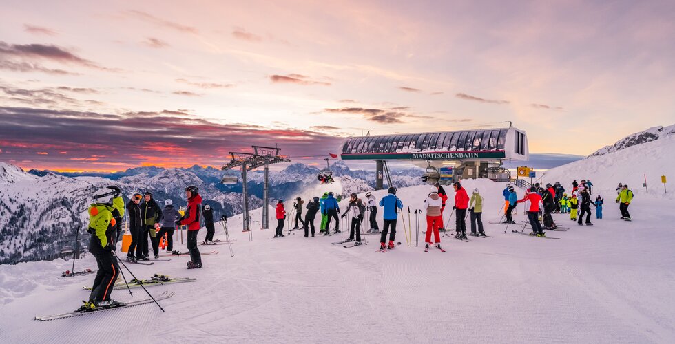 Skifahrer auf der Piste mit Blick auf den Sonnenaufgang