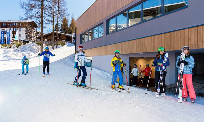 Skifahrer fahren direkt von der Piste in den hoteleigenen Skikeller