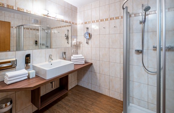 Großes Badezimmer mit Eckwaschtisch und Glasdusche
